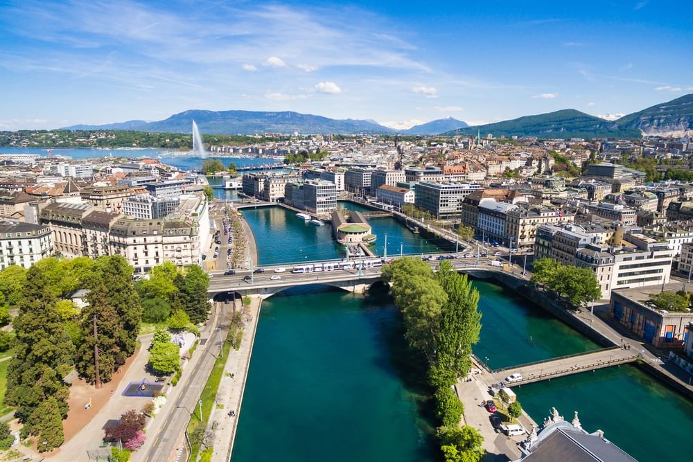 Aerial view of a city river by bridges under a clear sky near the waterfront near Warwick Geneva