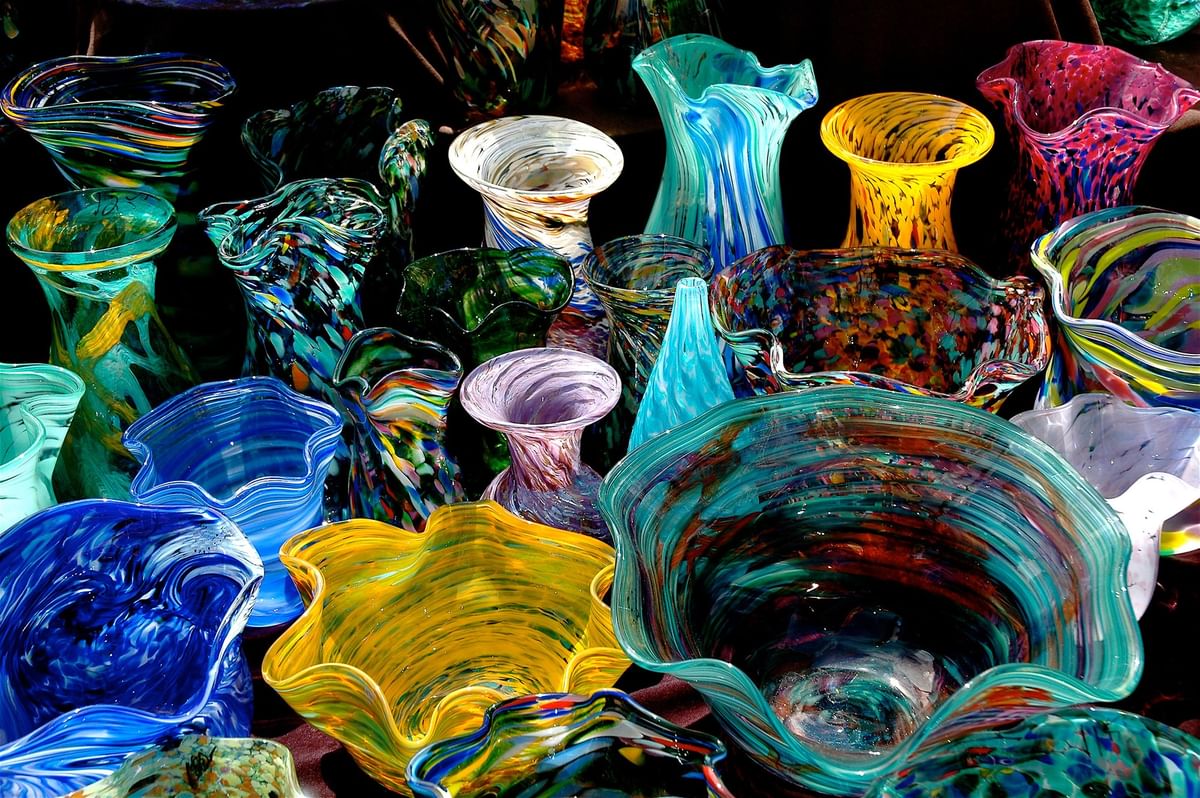 Collection of colorful hand-blown glass vases surrounding a display area at Warwick Seattle