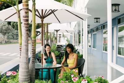 Friends dining under an umbrella at an outdoor bistro