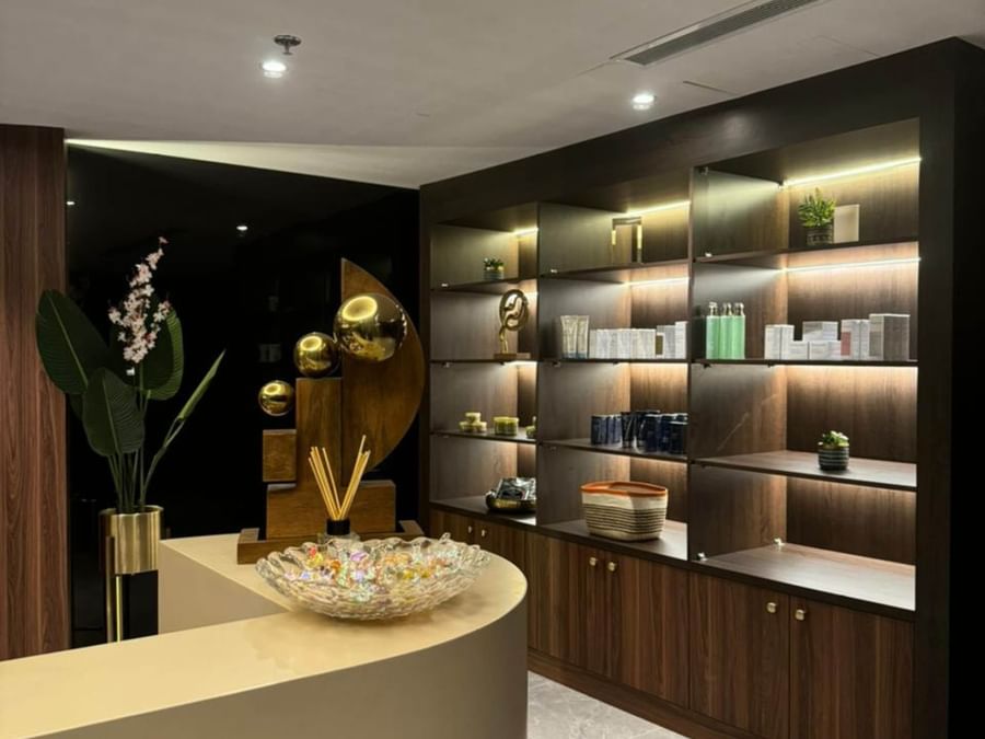 Decorative reception desk featuring a geometric wooden sculpture and products at Warwick Al Taif Hotel