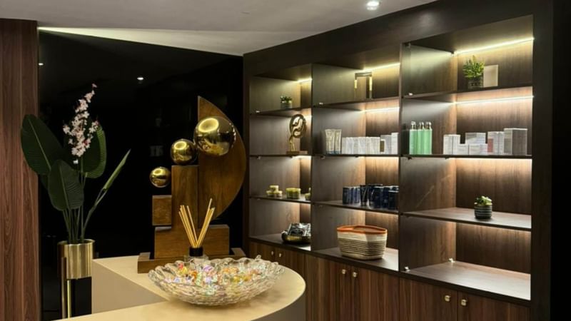 Modern reception area with sleek counter and lit shelves at Warwick Hotels and Resorts