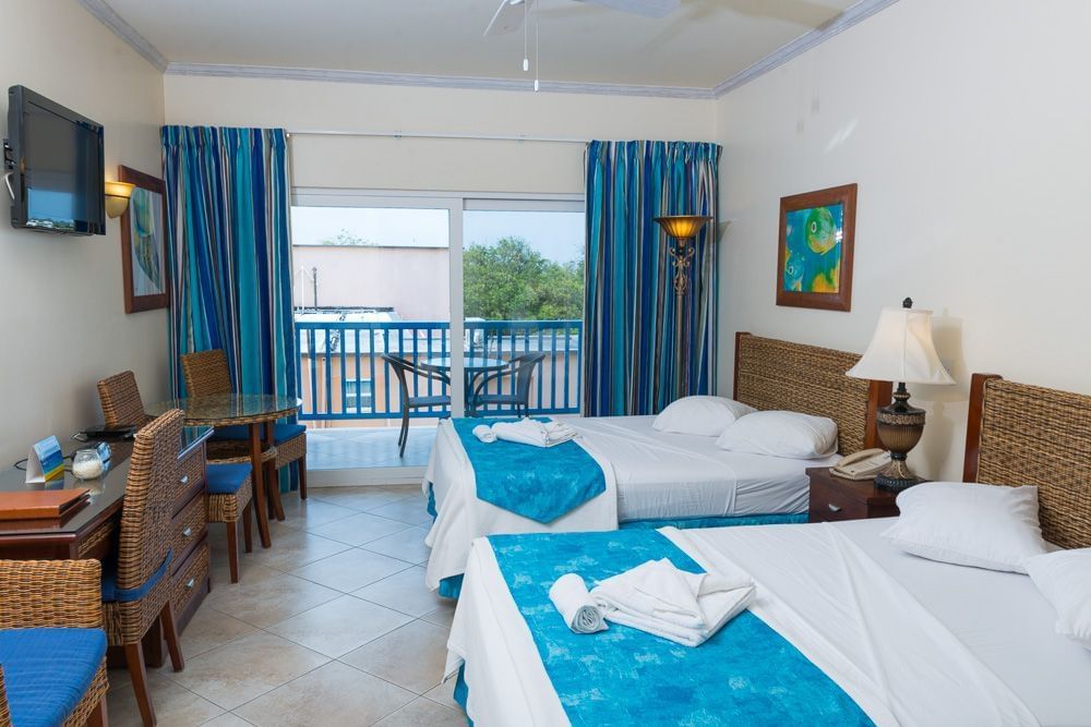 Deluxe Island View Studio with twin beds, wicker furniture, and balcony with a sea view at Rostrevor Hotel