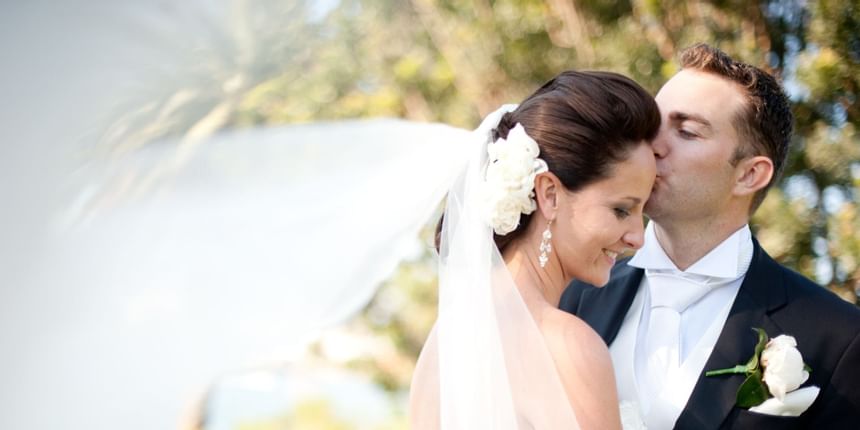 Groom kissing bride on her forehead at Gilman Hall Chattanooga