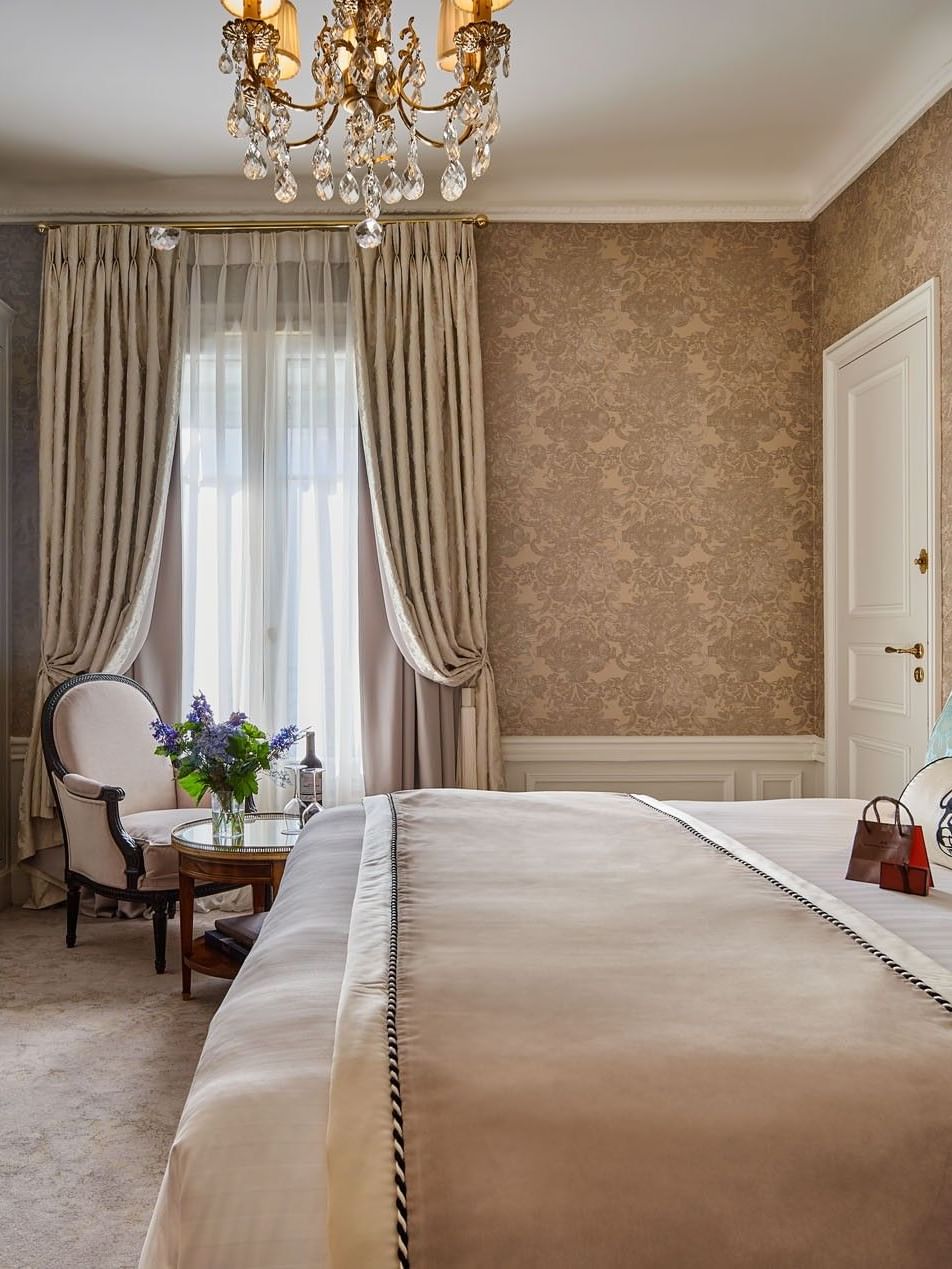 Bed with couch and wood cupboard near window in Executive Room - Rue de la Paix view at Hotel Westminster Paris