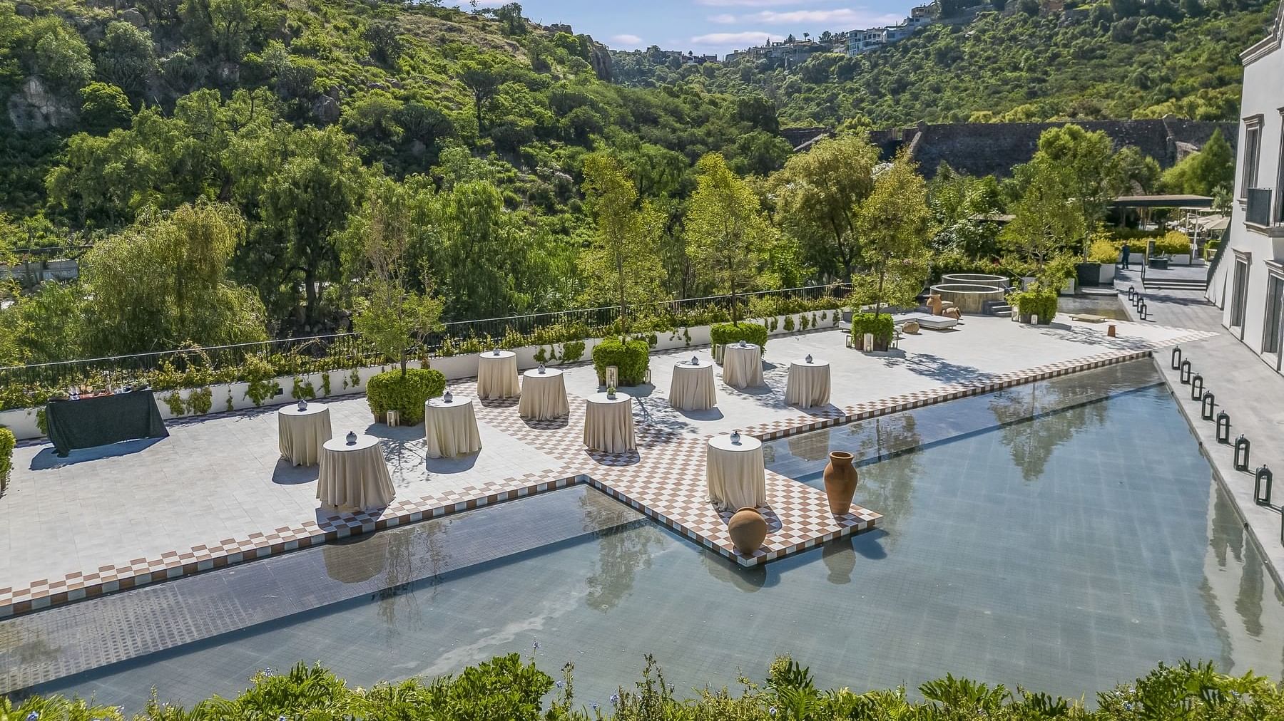 Pool with trees & mountainous landscape in the background at Live Aqua San Miguel de Allende