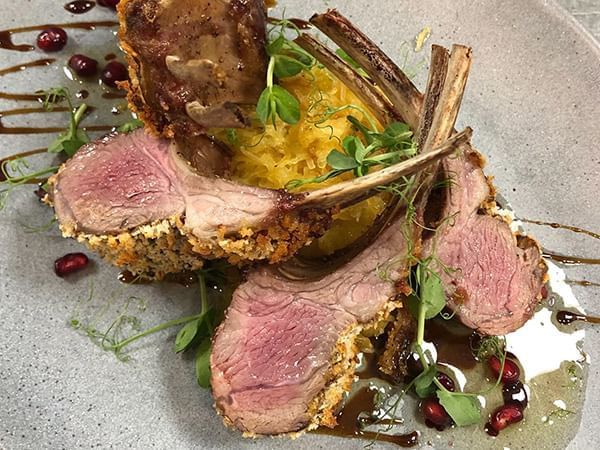 Perfectly cooked rack of lamb with a side of yellow rice and pomegranate in Apropos Restaurant & Bar at The Abbey Inn & Spa