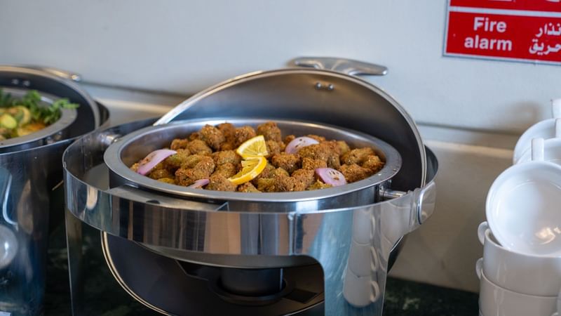 Buffet with assorted food and lemon slices in a silver container at Saja by Warwick Madinah.