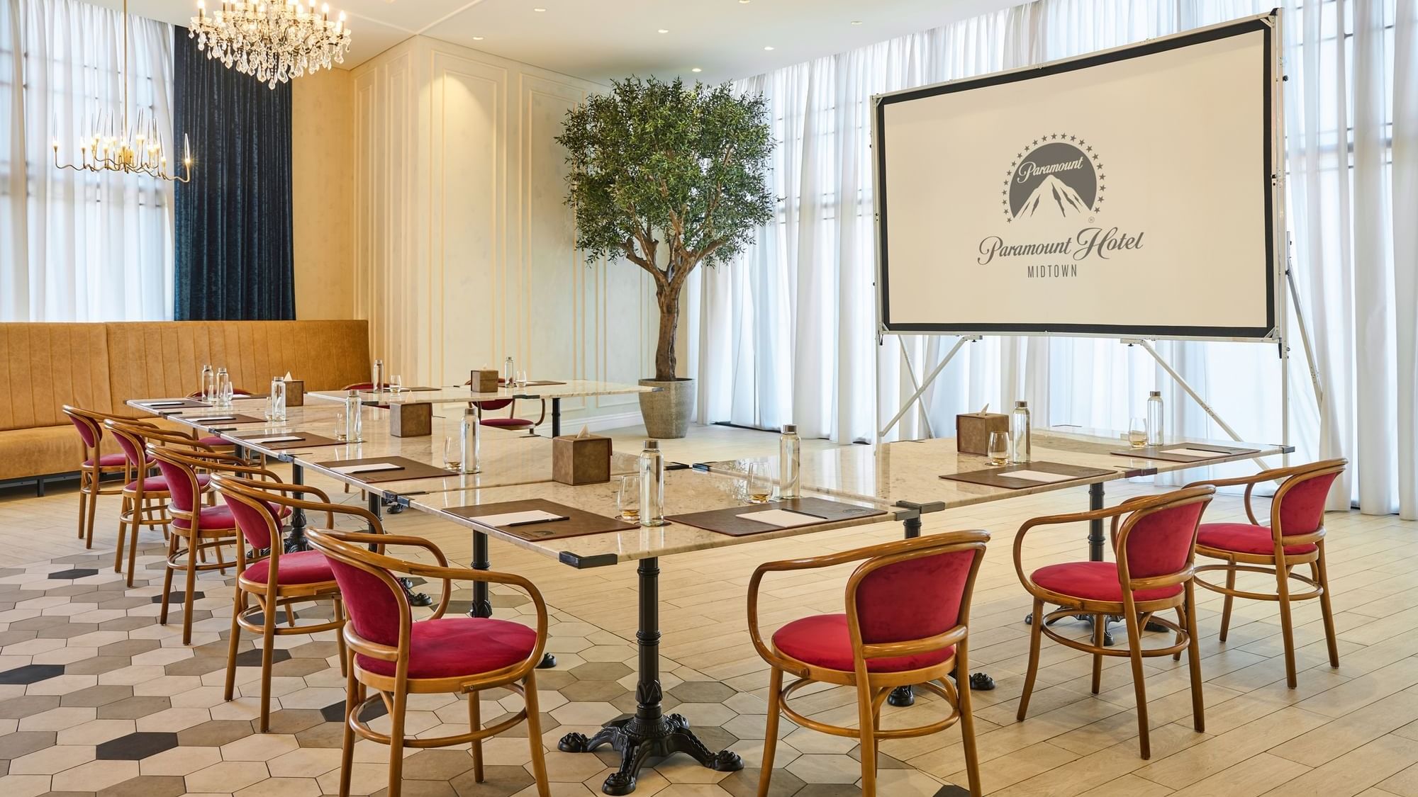 Paparazzi restaurant venue setup with a projector screen displaying the paramount hotel midtown logo and comfortable seating