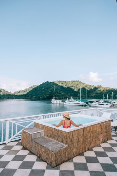 Woman in a hot tub overlooking a body of water from the Amaka Ocean Living Lodge
