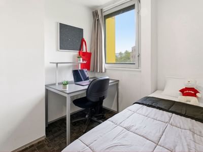 Clean room with a desk, laptop, and a bed at Student Living Auckland Anzac.
