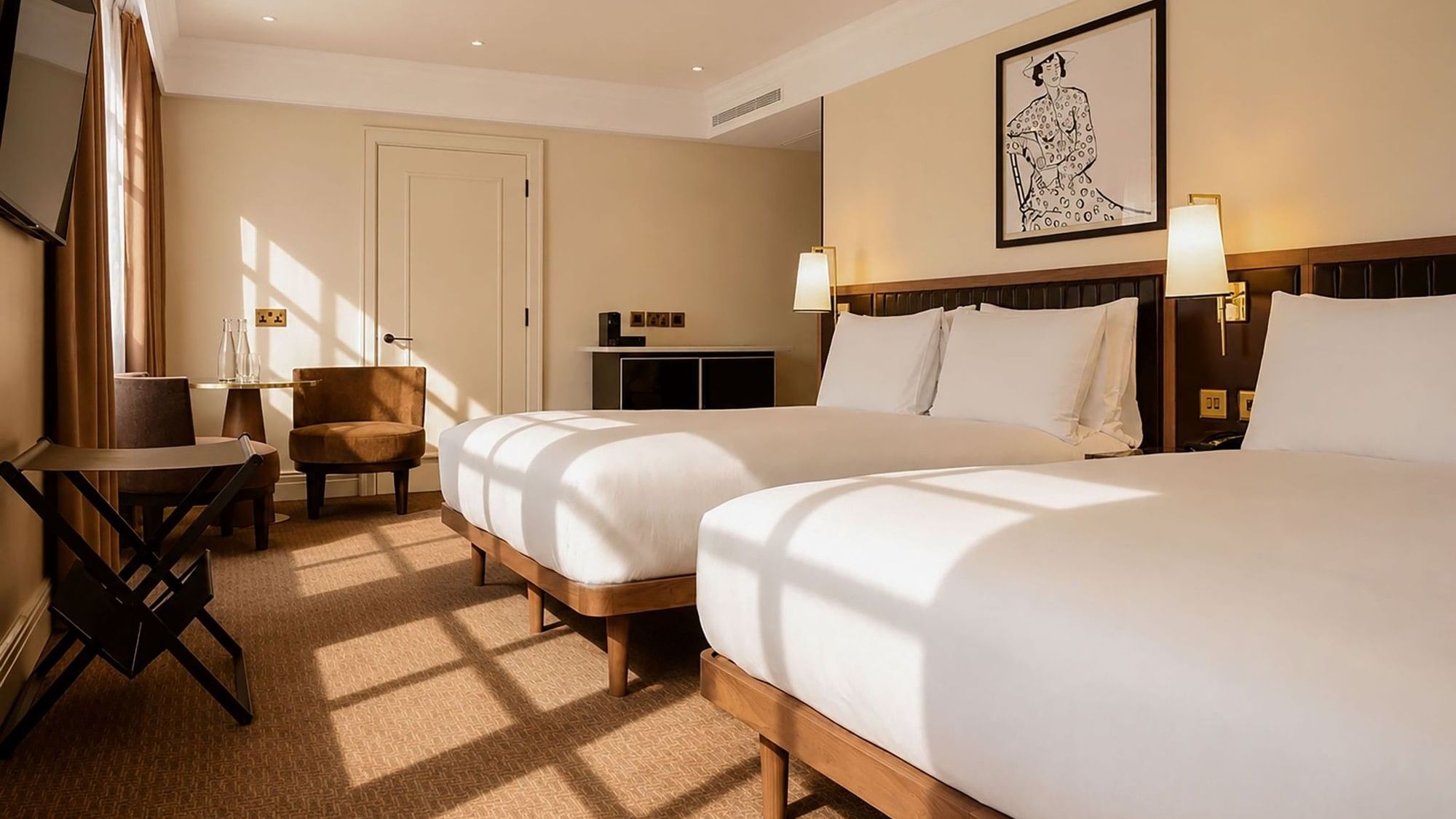 Family Room with two beds, modern furnishings, and natural light at The May Fair Hotel, London