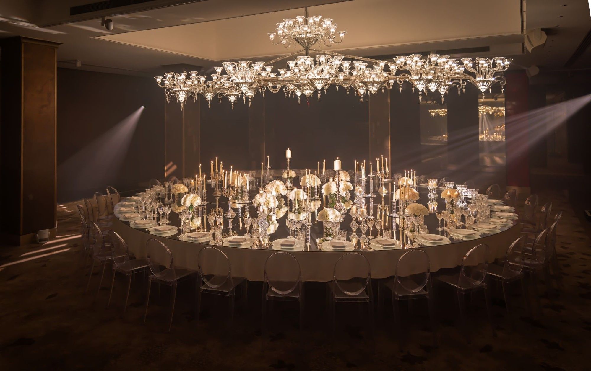 Grand dining table set with elegant decor under a large crystal chandelier at The May Fair Hotel London