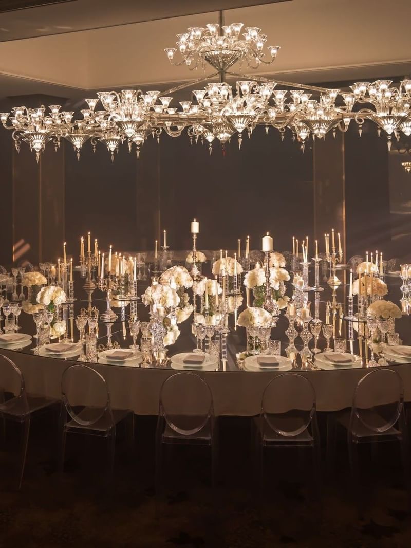 Elegant banquet hall with round table set for formal dining, crystal chandeliers, and candlelight in The Crystal Ballroom at The May Fair Hotel, London