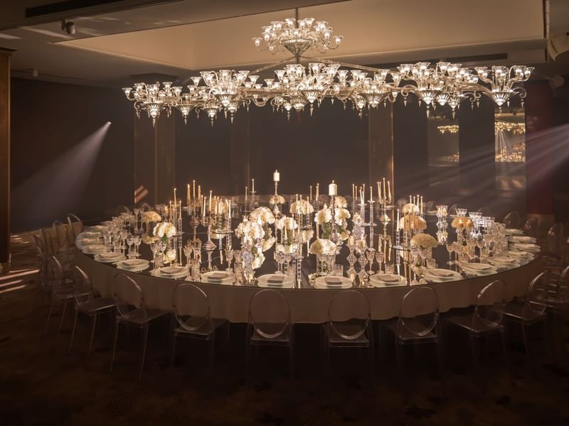 Elegant banquet hall with round table set for formal dining, crystal chandeliers, and candlelight in The Crystal Ballroom at The May Fair Hotel, London