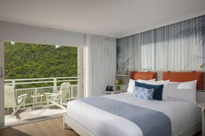2 Queen Bed with Courtyard View avec un lit douillet et un coin salon sur le balcon à Saint Martin Beach Resort & Spa