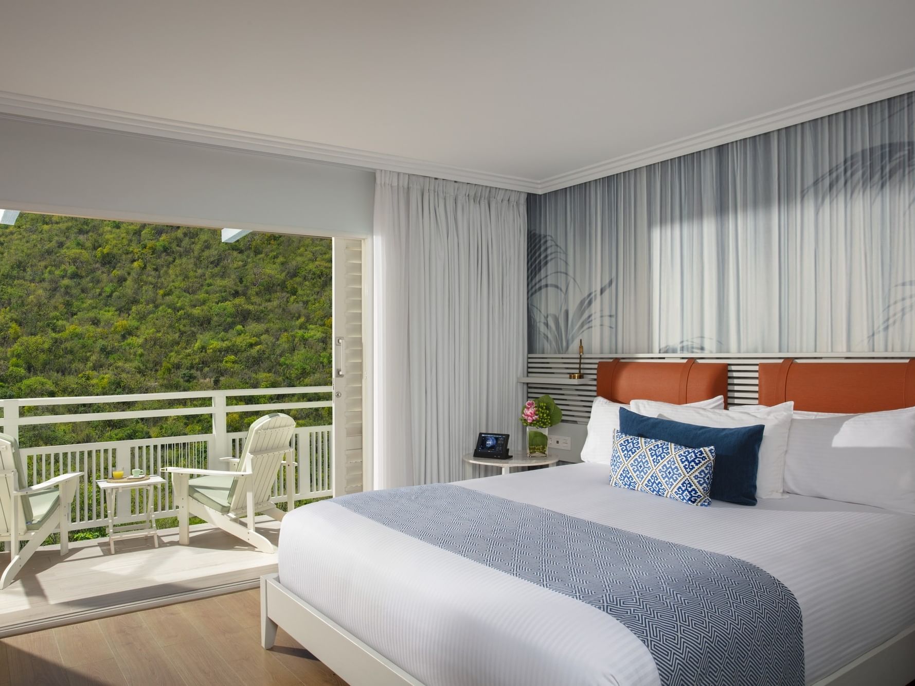 Nightstand by the cozy bed in 2 Room Suite Courtyard with a balcony seating area at Saint Martin Beach Resort & Spa