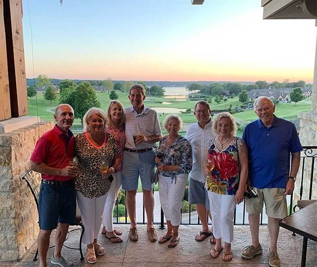 Elderly couples posing on a balcony with a golf course backdrop at Shangri-La Monkey Island