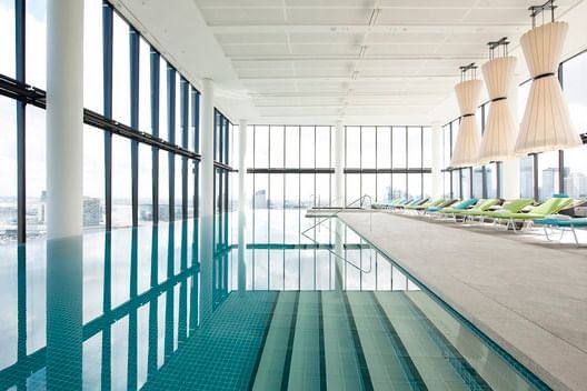 Indoor pool area with pool chairs at Crown Metropol Melbourne