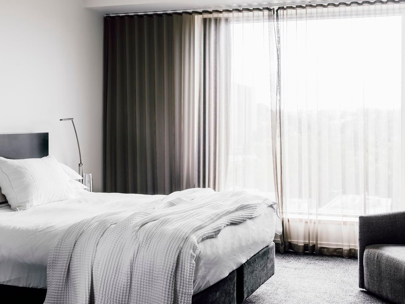 King bed by a window in Superior room at The Como Melbourne