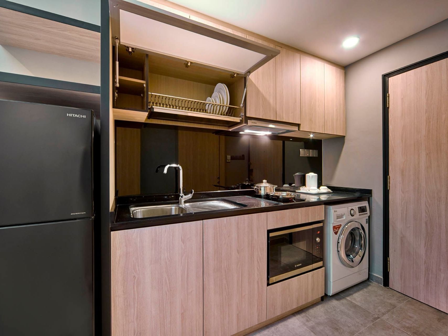 Image 25: Sleek Studio Twin kitchen with wooden cabinets, stainless appliances, and a modern, functional layout at Orchard Grand Court