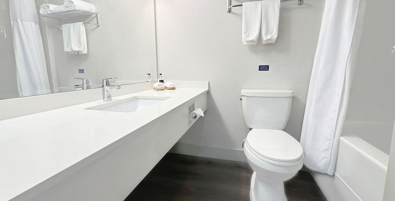 Washroom with toilet, sink, soap, and towels