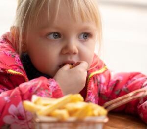 Close-up of a kid eating french fries at Rosen Inn Universal