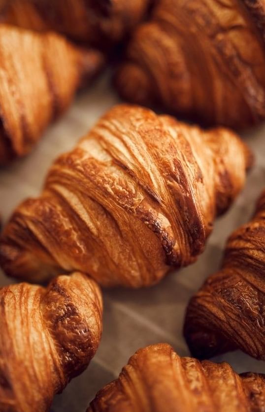 Delicious close-up of several flaky, golden-brown baked croissants at The Met Hotel Leeds, England