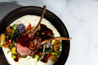 Elegant and beautifully plated rack of lamb with assorted vegetables served at The Boulevard Inn & Bistro