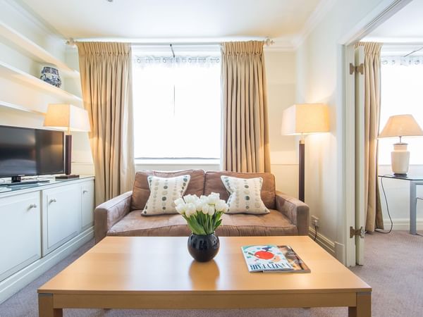 Living room with sofas, tv and tables at The Capital By Warwick