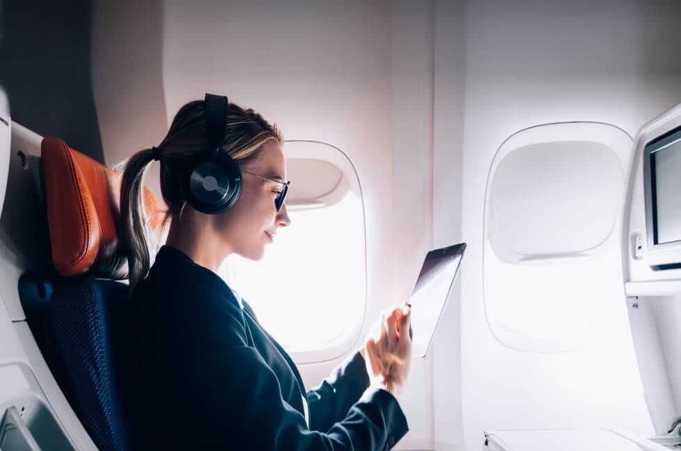 Una niña escuchando música usando tab en el avión, Fiesta Inn