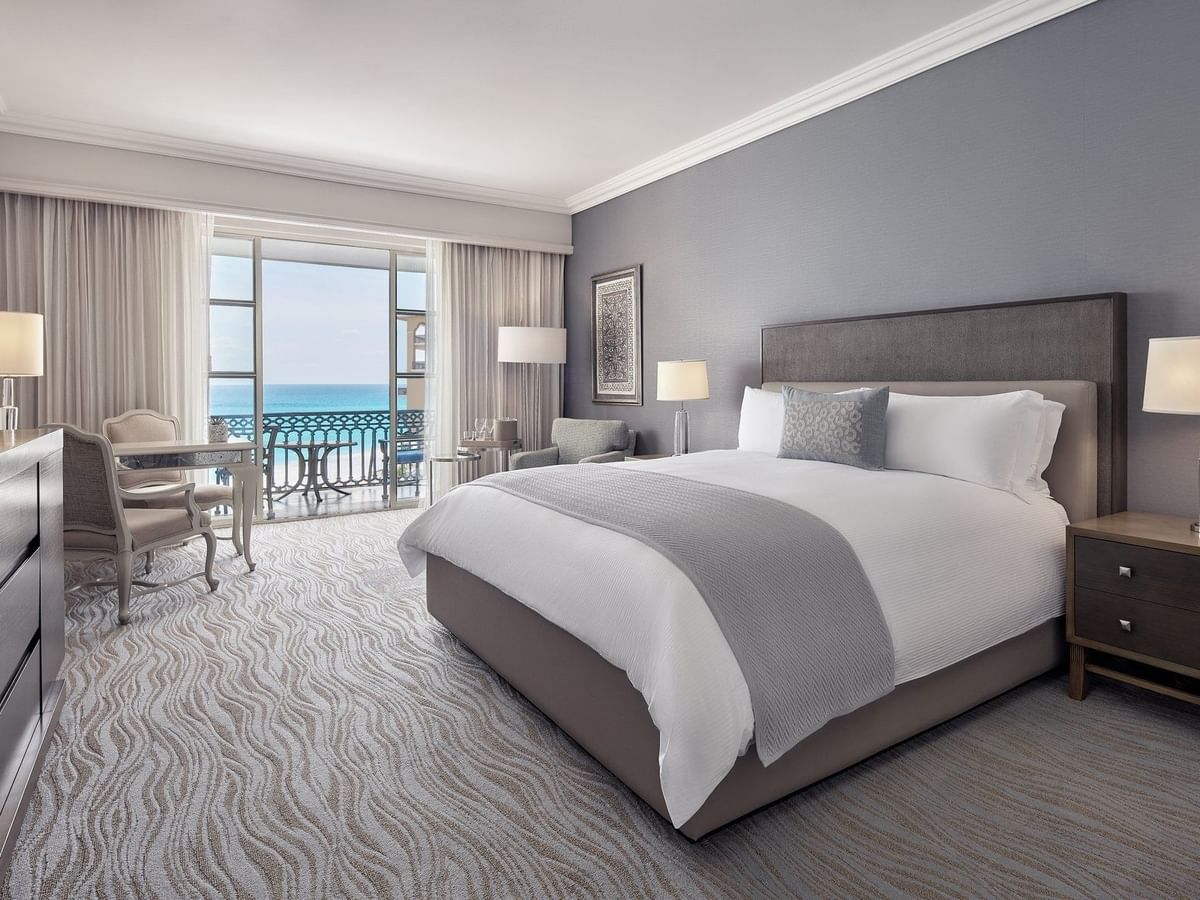 Workspace facing the bed in Deluxe Seafront King Room with carpeted floors at Kempinski Hotel Cancún