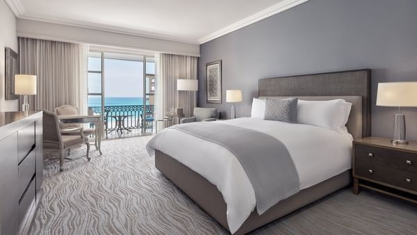 Workspace facing the bed in Deluxe Seafront King Room with carpeted floors at Kempinski Hotel Cancún