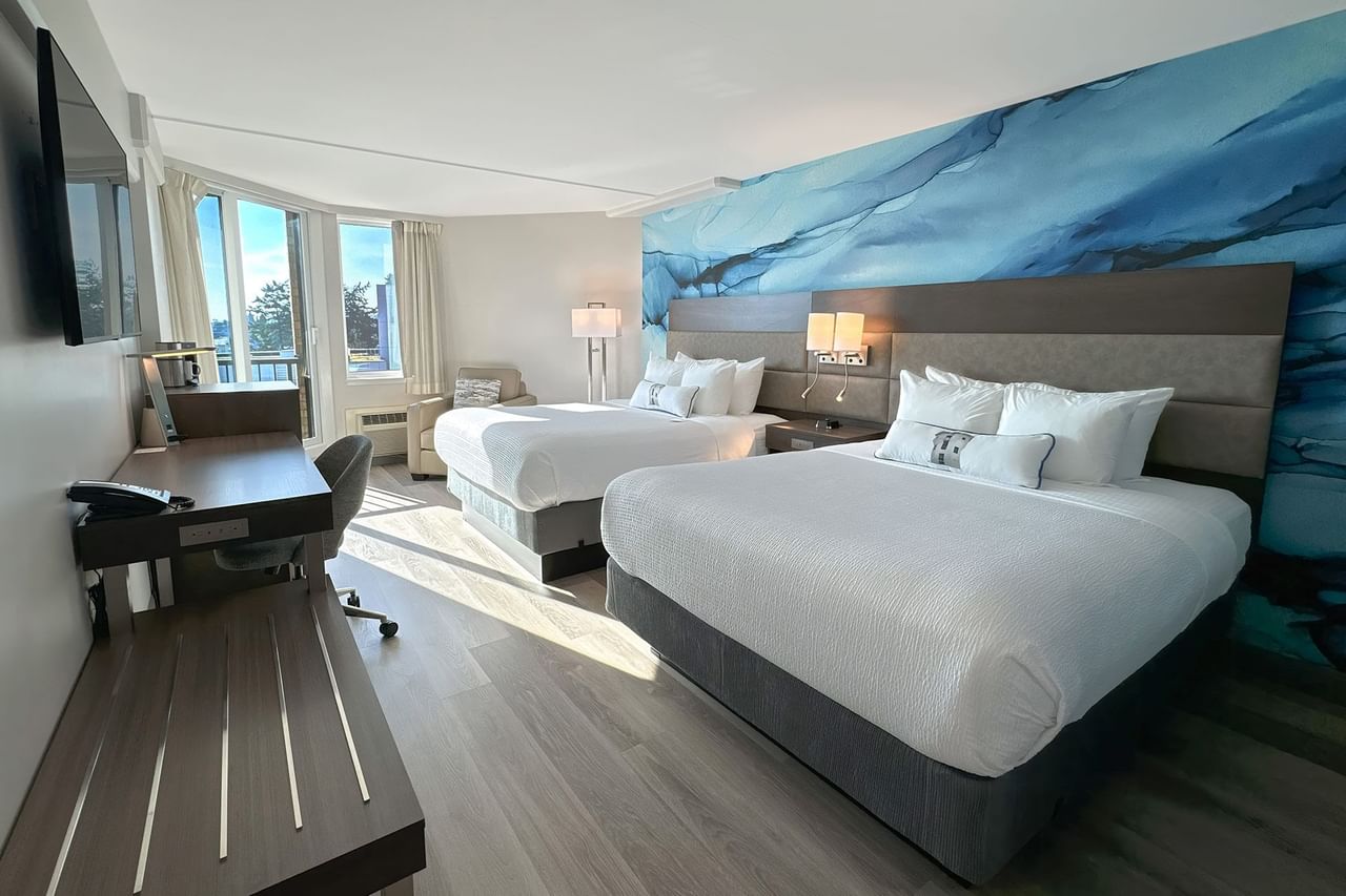 Hotel guestroom with two queen beds and a blue wall mural