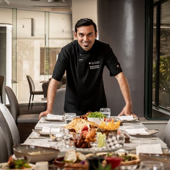 Chef arranging a dining table in a restaurant at Pullman Sydney Hyde Park