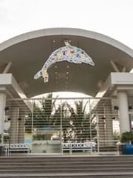Entrance of Fakieh Aquarium with a large, colorful dolphin decoration above near Warwick Hotel Jeddah