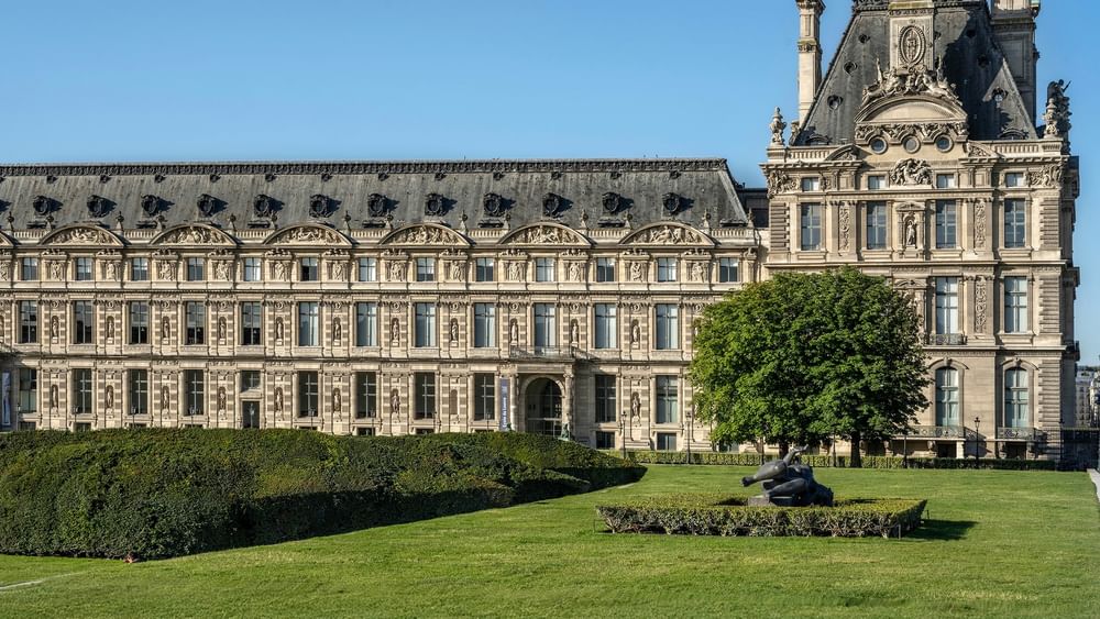 Grand historic building with lush lawns and sculptures in Paris near Warwick Hotels & Resort