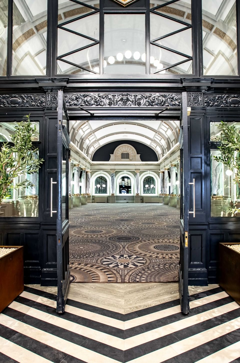 Grand entrance to the spacious event hall at The Met Hotel Leeds, England, featuring a chevron floor and a historic clock