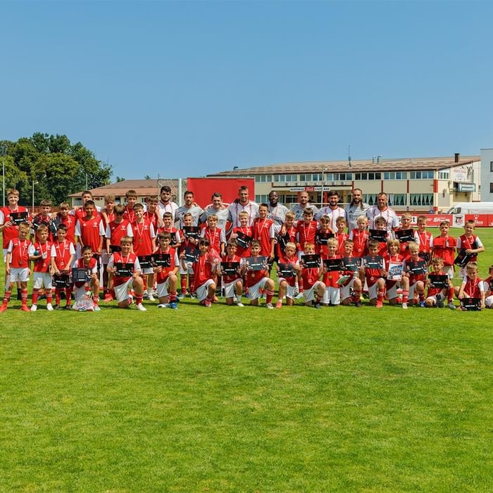 Nogometni tim s medaljama i pokalima na travnjaku Falkensteiner Resort Punta Skala