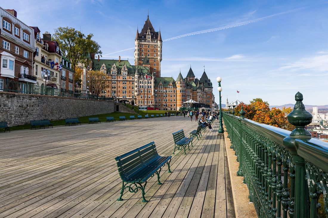 Promenade en bois avec bancs et vue sur le Château Frontenac au loin chez Warwick Le Crystal Montreal
