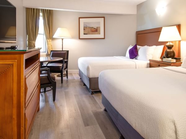 Hotel guestroom with two queen beds and TV