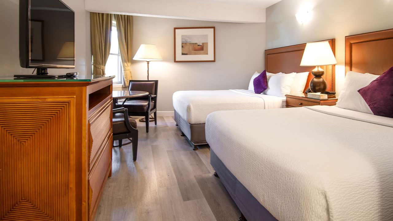 Hotel guestroom with two queen beds and TV