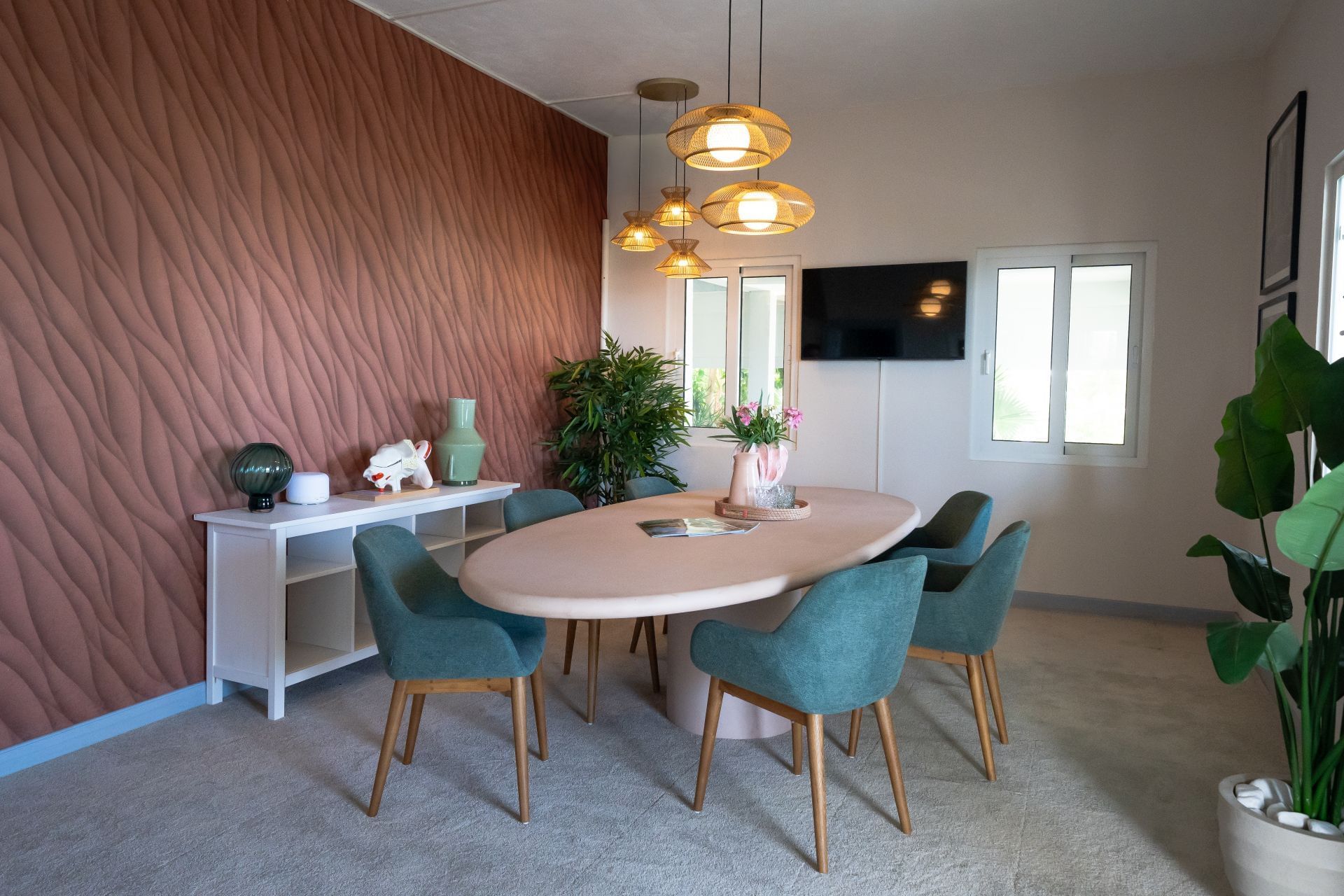 Moderne zithoek met een ovalen tafel omringd door turquoise stoelen in Tinnitus Relief Therapy bij Golden Rock Resort