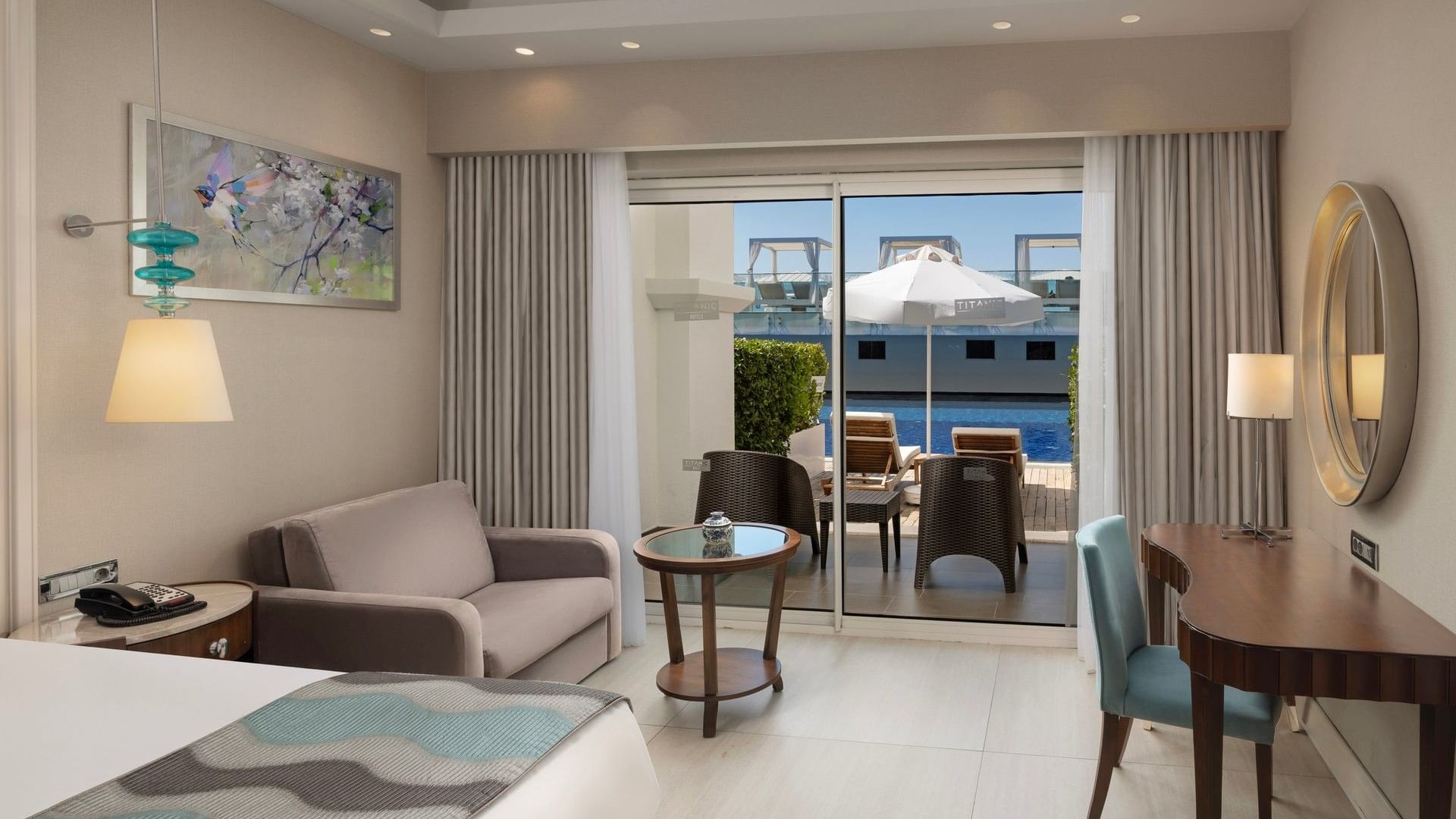 Светлый номер с выходом к бассейну, мебелью и видом на террасу в Titanic Deluxe Golf Belek, Анталья.