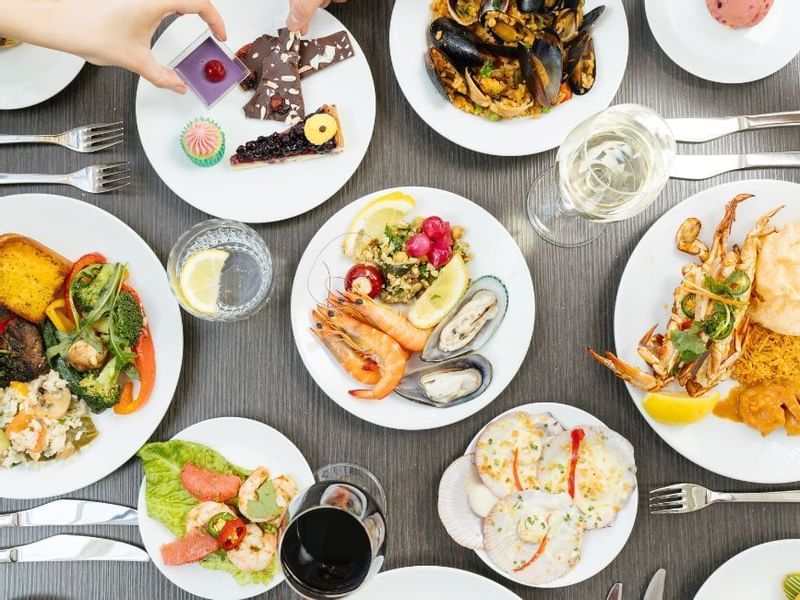 Table with assorted seafood dishes, glasses of wine served in restaurant at Crown Hotels Perth