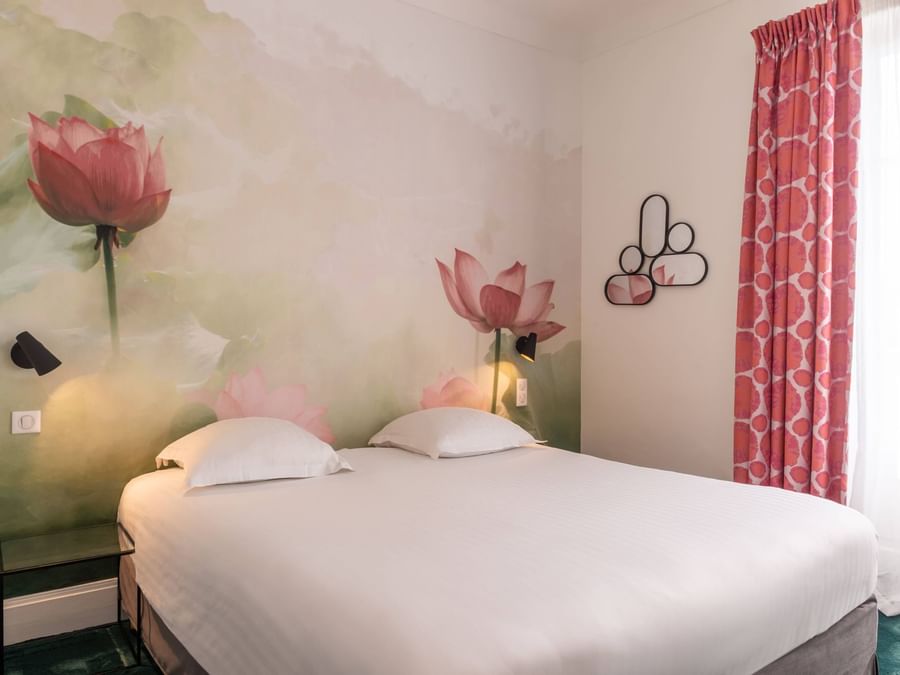 Double bed with elegant wall art in a room at Originals Hotels