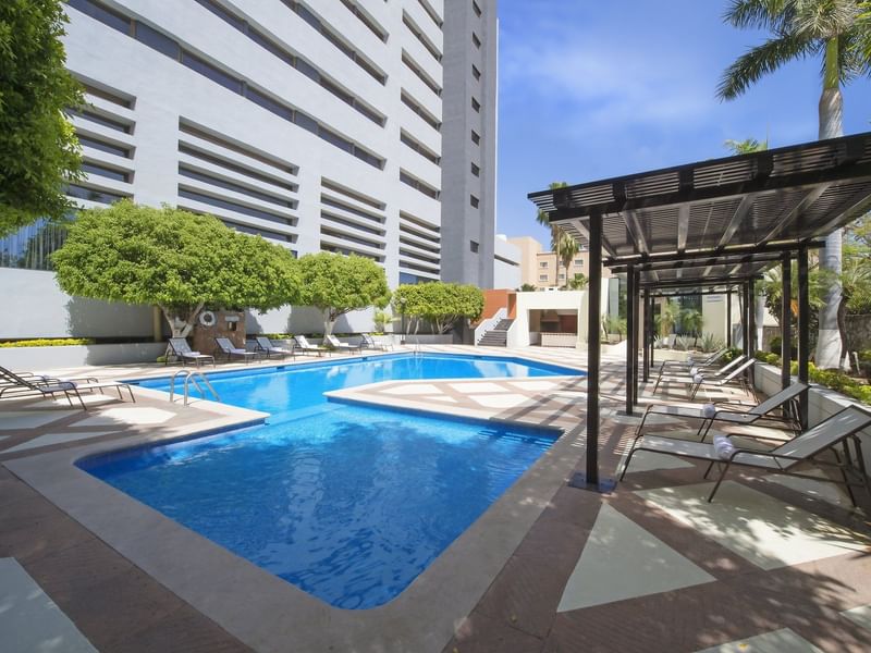 Pool area with lounge beds at Fiesta Americana Hermosillo
