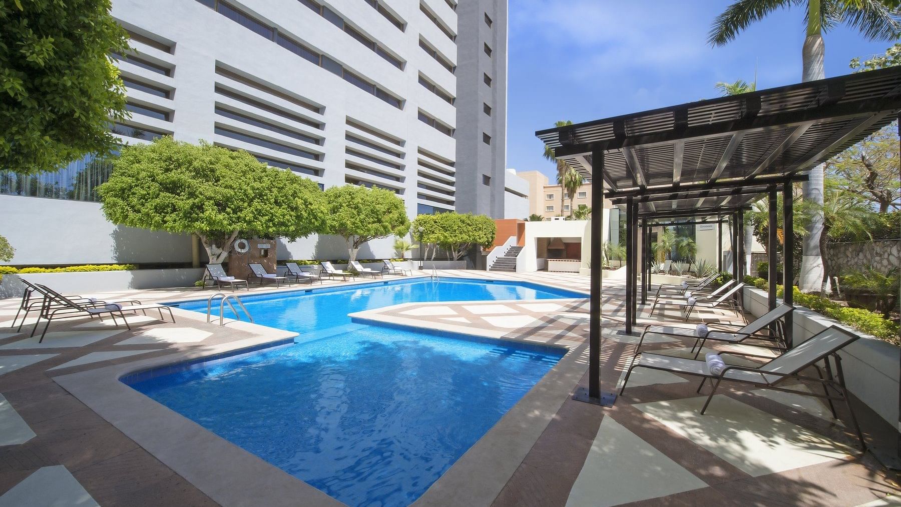 Pool area with lounge beds at Fiesta Americana Hermosillo