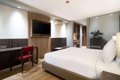 TV and work desk facing the cozy bed in Executive Queen Room at Habitel Prime Hotel, offering stylish accommodation in Bogota