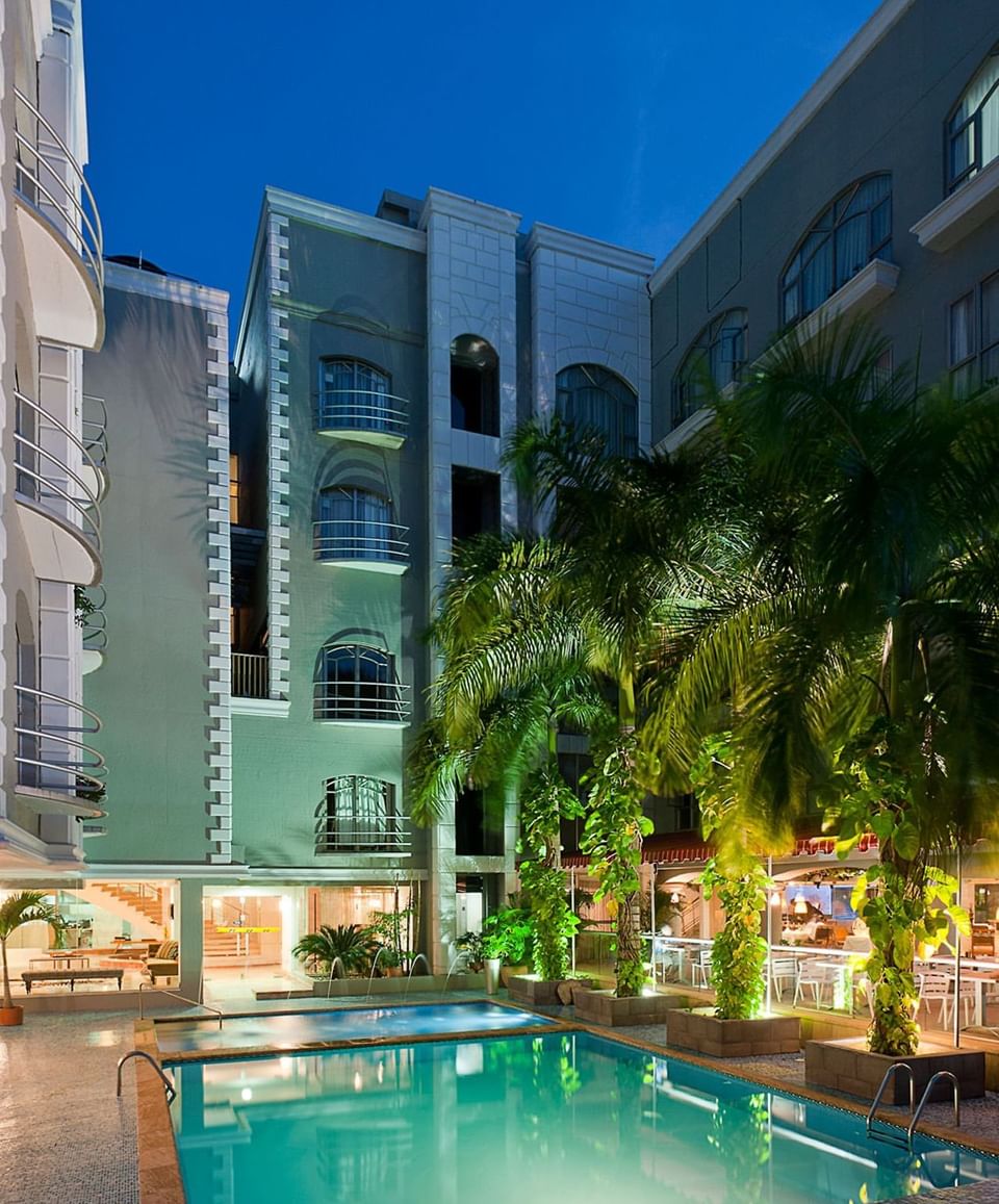 Evening photo of the Country International Hotel pool and courtyard, highlighting spacious Barranquilla hotel rooms