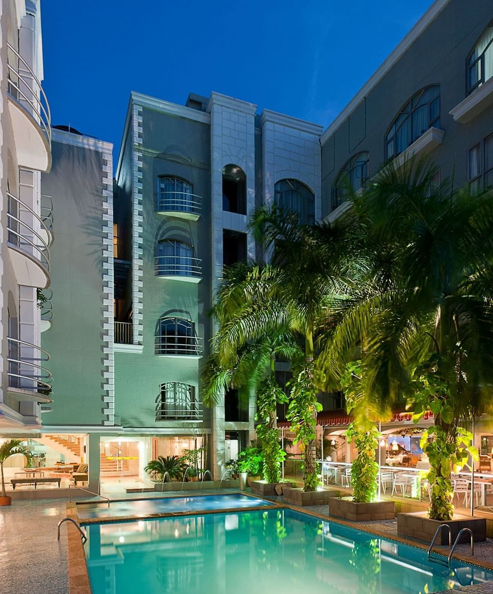 Evening photo of the Country International Hotel pool and courtyard, highlighting spacious Barranquilla hotel rooms